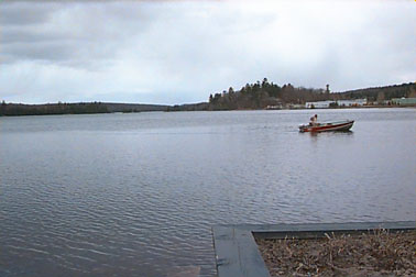 First fisherman on Elliot Lake after ice melted, on rainy Spring Day